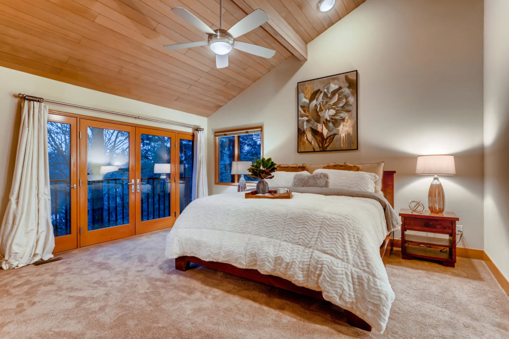 real estate image of master bedroom with wood paneled ceilings