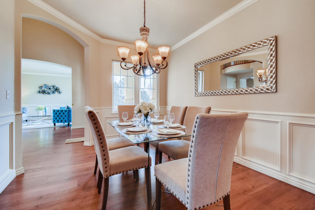 real estate image of a dining room with pastel chairs