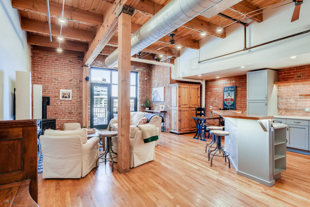 Living room loft with brick wall and exposed beams